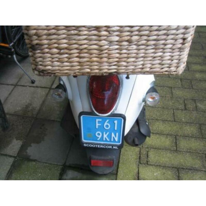 schatige snor scooter uit 2012 met een klein mandje